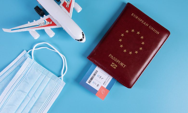 Airplane, passport, airline ticket, mask on blue background