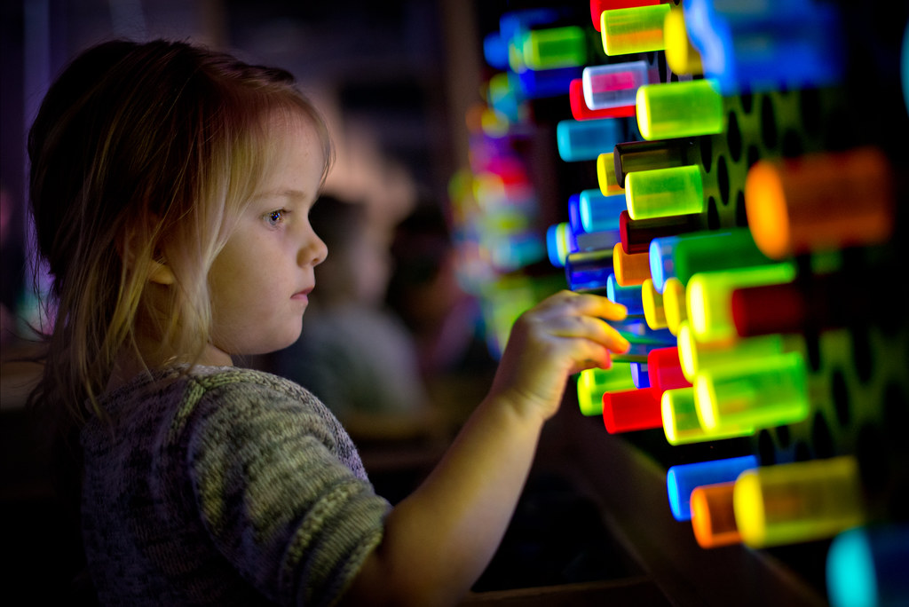 A child playing with lights at the Thinkery