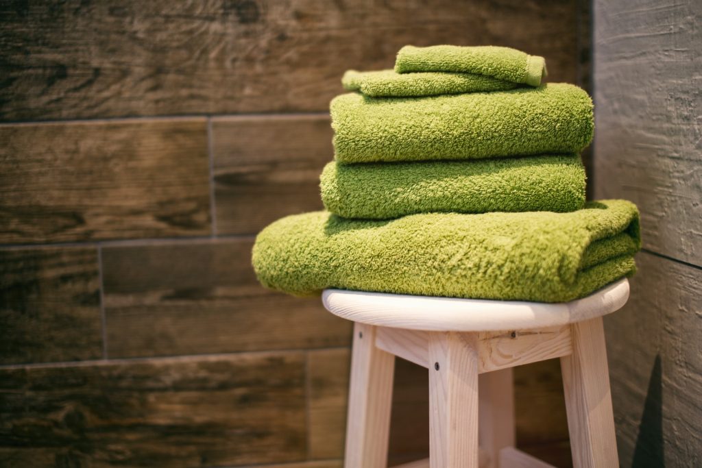 multiple green towels on stool