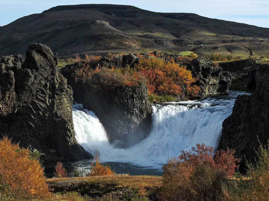 A scenic view of Hjálparfoss Waterfall