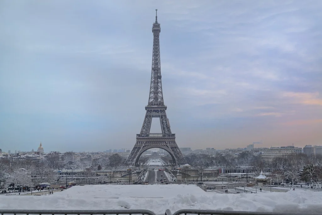 The Eiffel Tower in a snowstorm with the pont d’Iéna and the river Seine in the foreground.